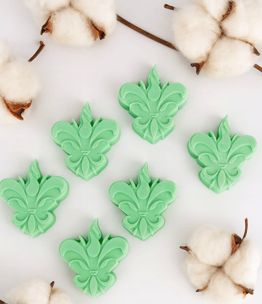 Pack de 6 wax melts Eternal Greenwood da Candlys, em verde menta e formato flor-de-lis, fotografados num cenário clean com ramos de algodão. Fragrância: patchouli e ylang ylang.