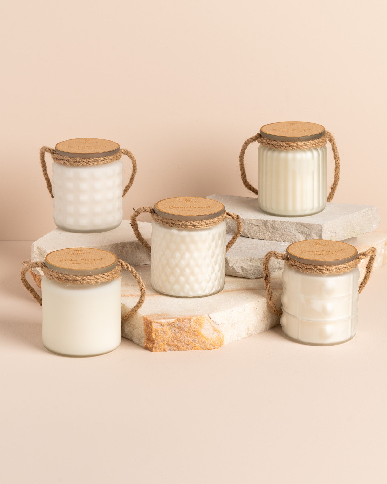 Conjunto de 5 velas artesanais Brides Bouquet com copos branco fosco em diferentes padrões esculpidos, em composição decorativa harmoniosa.
