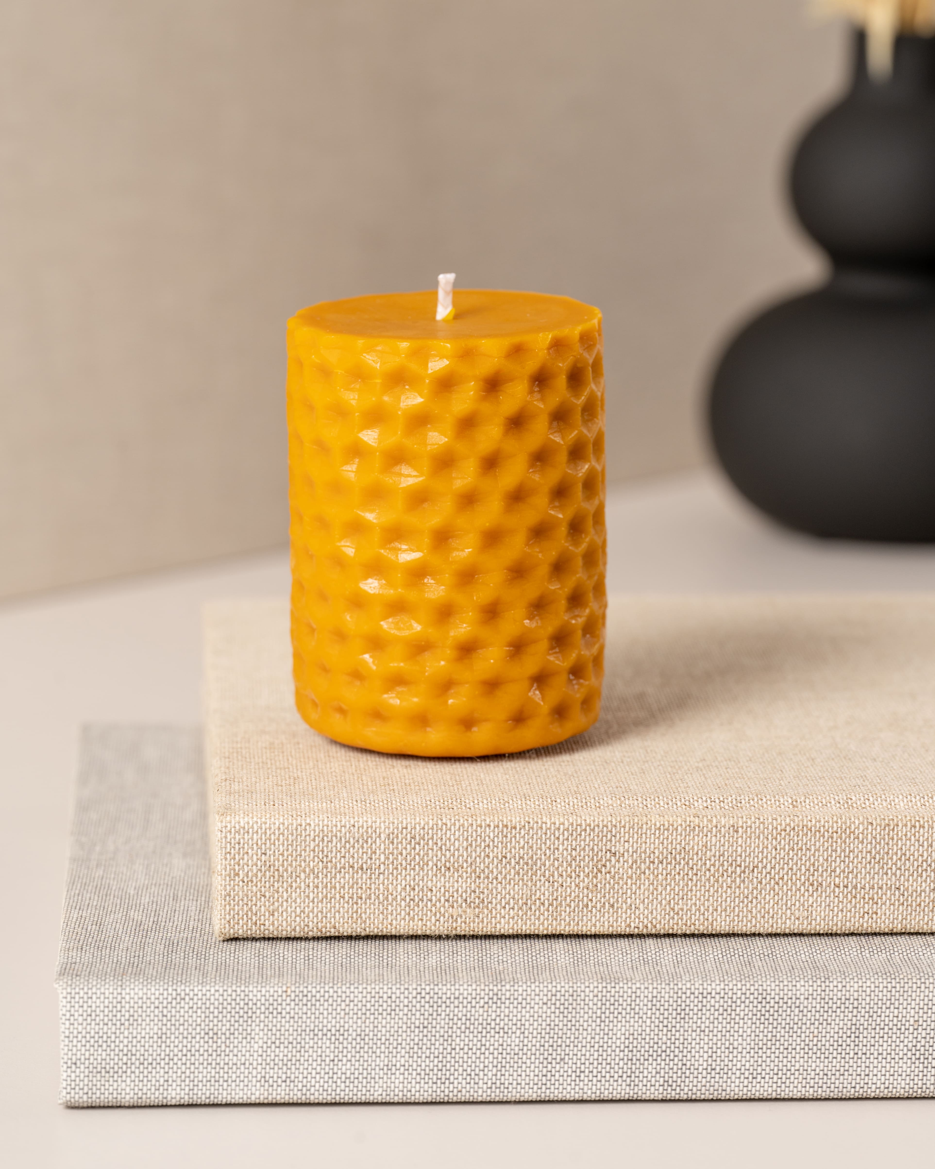 Vela artesanal cilíndrica em cera de abelha pura da Candlys, com padrão em relevo inspirado nos favos de mel. Produzida de forma natural e sustentável, esta peça oferece um toque rústico, elegante e ecológico para qualquer ambiente.
