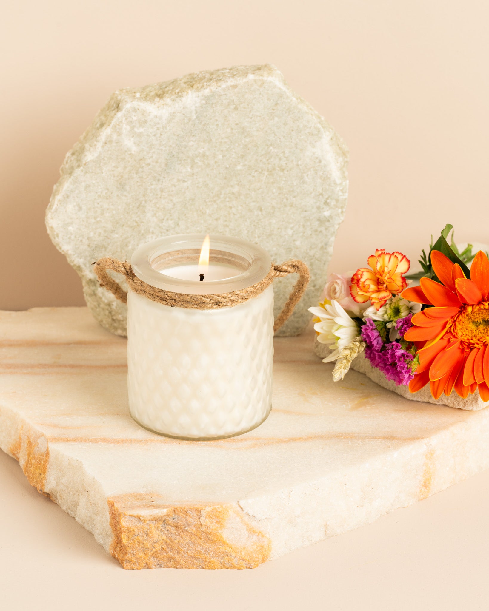 Vela aromática artesanal Bouquet de Noiva em copo branco fosco com relevo diamante e corda natural, decorada com flores campestres.