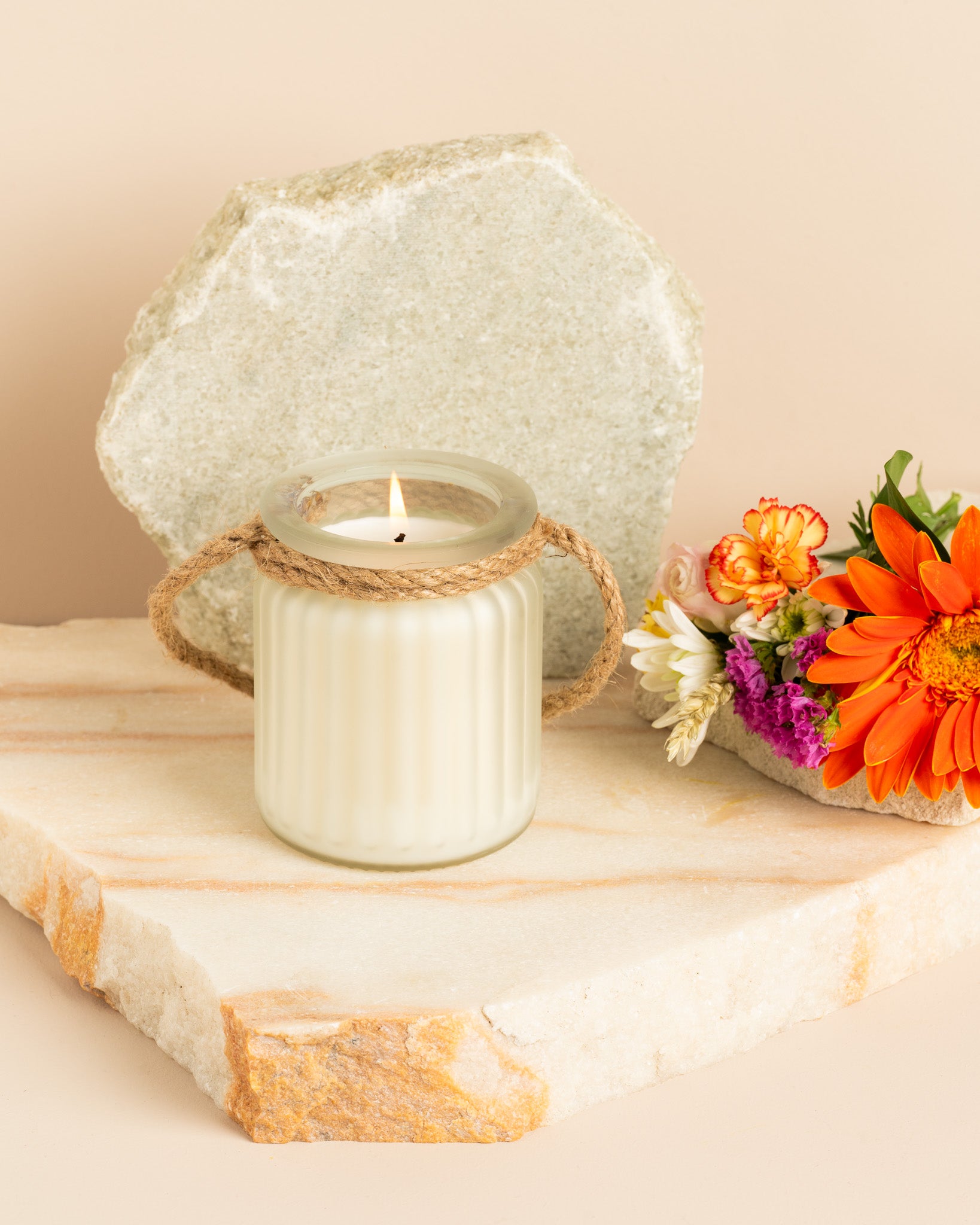Vela aromática Brides Bouquet em copo branco fosco com relevo vertical, alça de corda natural e aroma floral campestre.