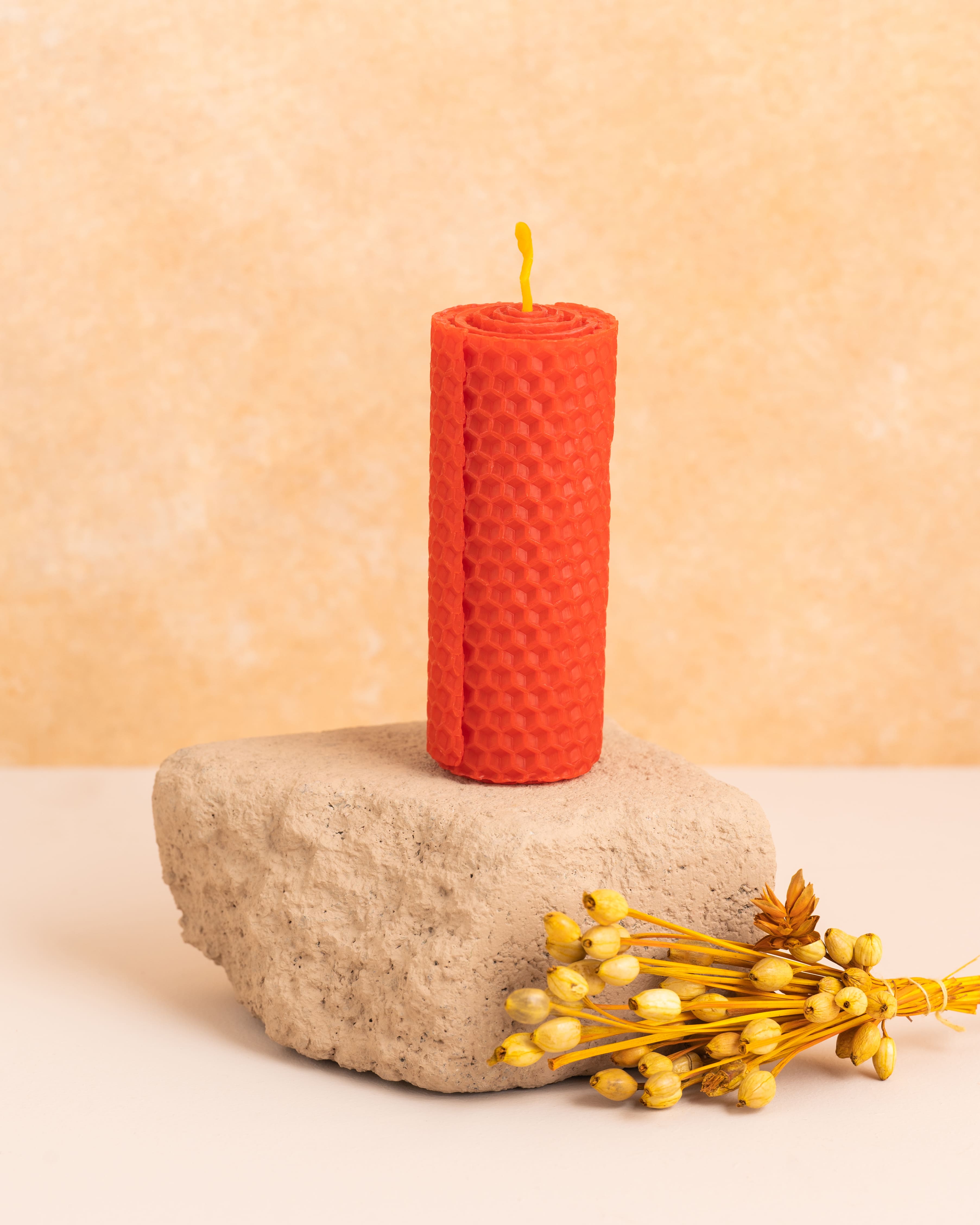Vela em cera de abelha cor escarlate com 10 cm de altura, produzida a partir de folhas de cera enroladas. Estrutura hexagonal inspirada nos favos de mel, perfeita para um ambiente puro e sofisticado.