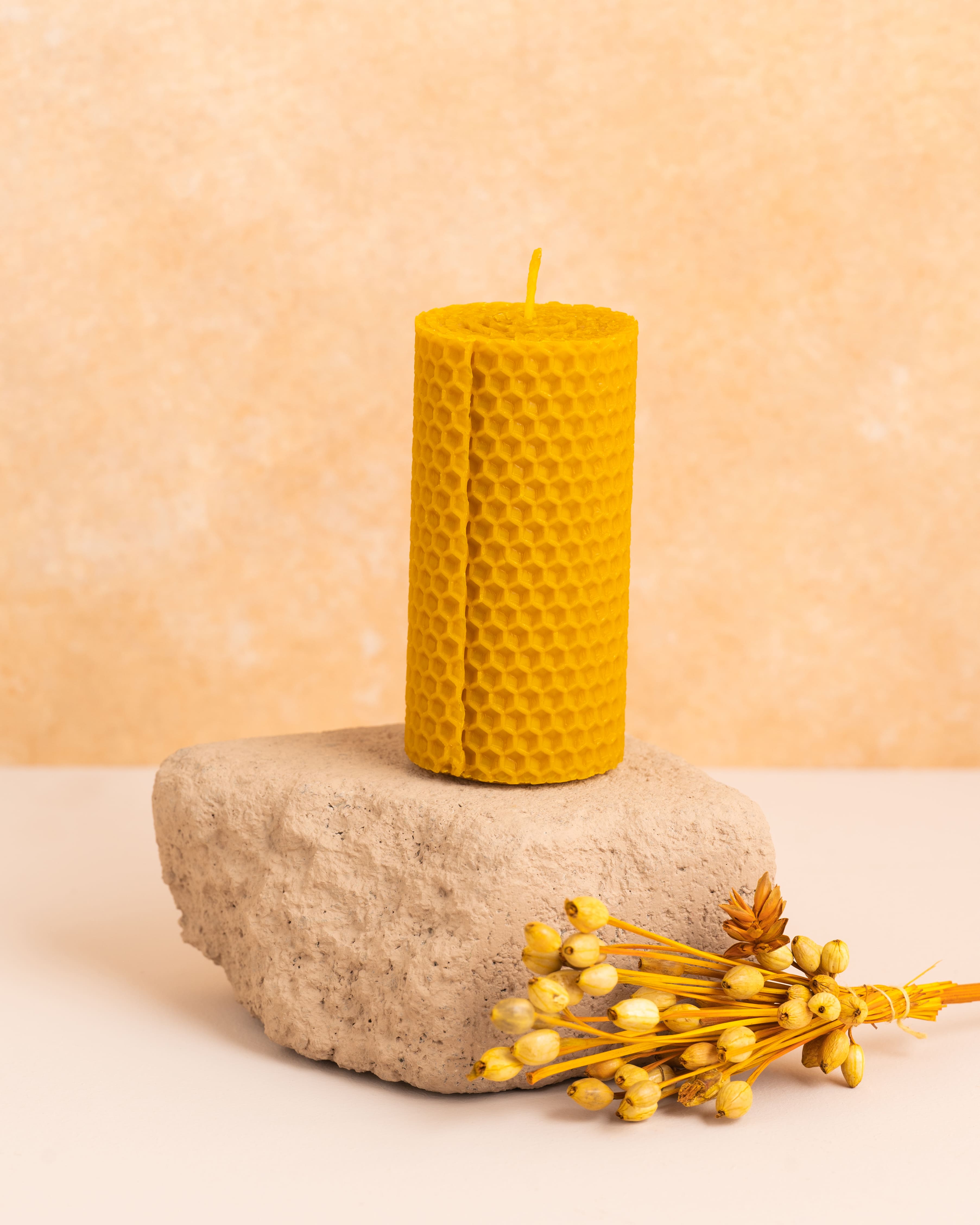 Vela em cera de abelha pura com 10 cm de altura, produzida a partir de folhas de cera enroladas. Estrutura hexagonal natural inspirada nos favos de mel, perfeita para ambientes acolhedores e sustentáveis.