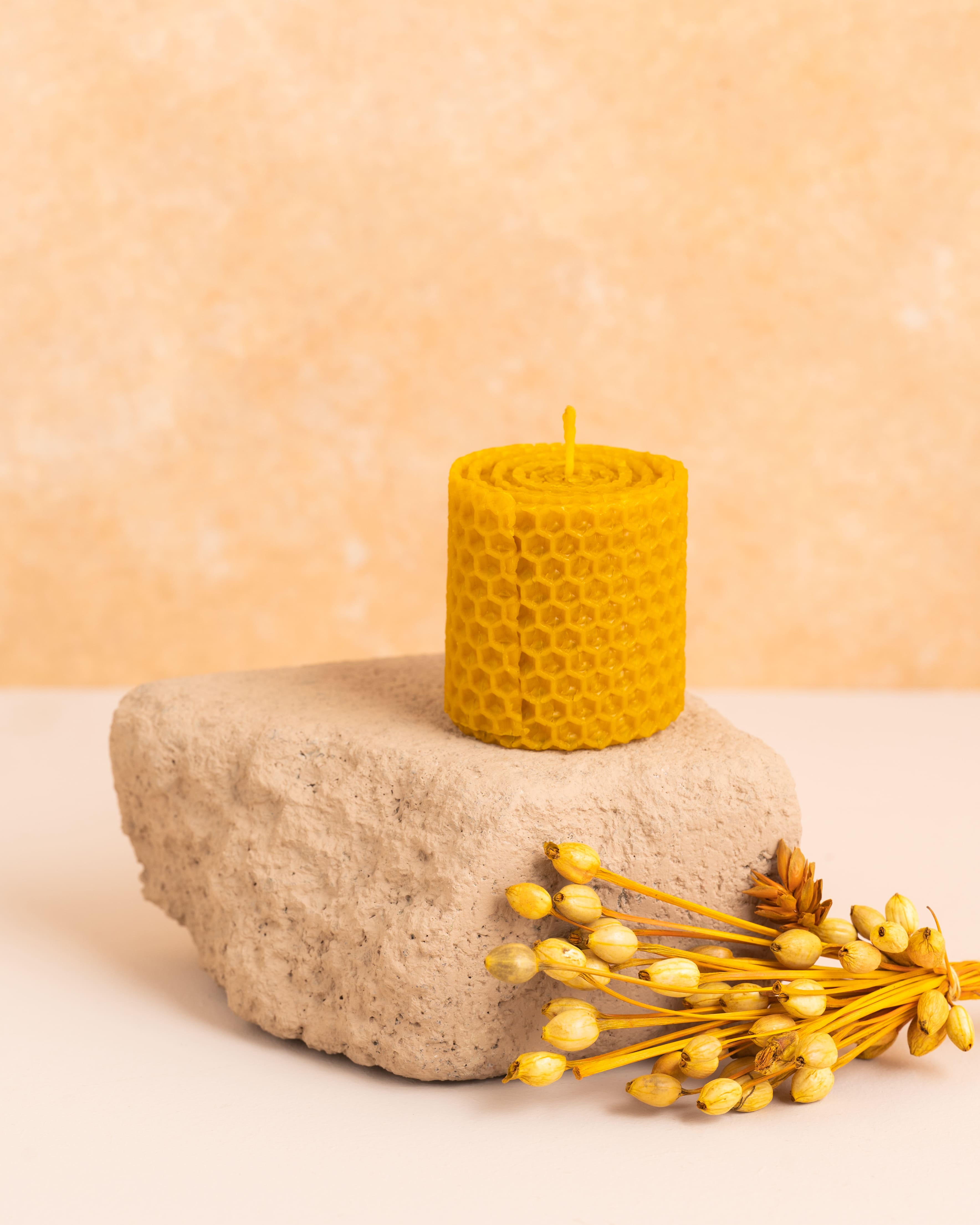 Vela artesanal em cera de abelha pura com 5 cm de altura, feita a partir de folhas de cera enroladas. Padrão hexagonal dos favos de mel em detalhe, ideal para pequenos apontamentos decorativos e aromáticos.