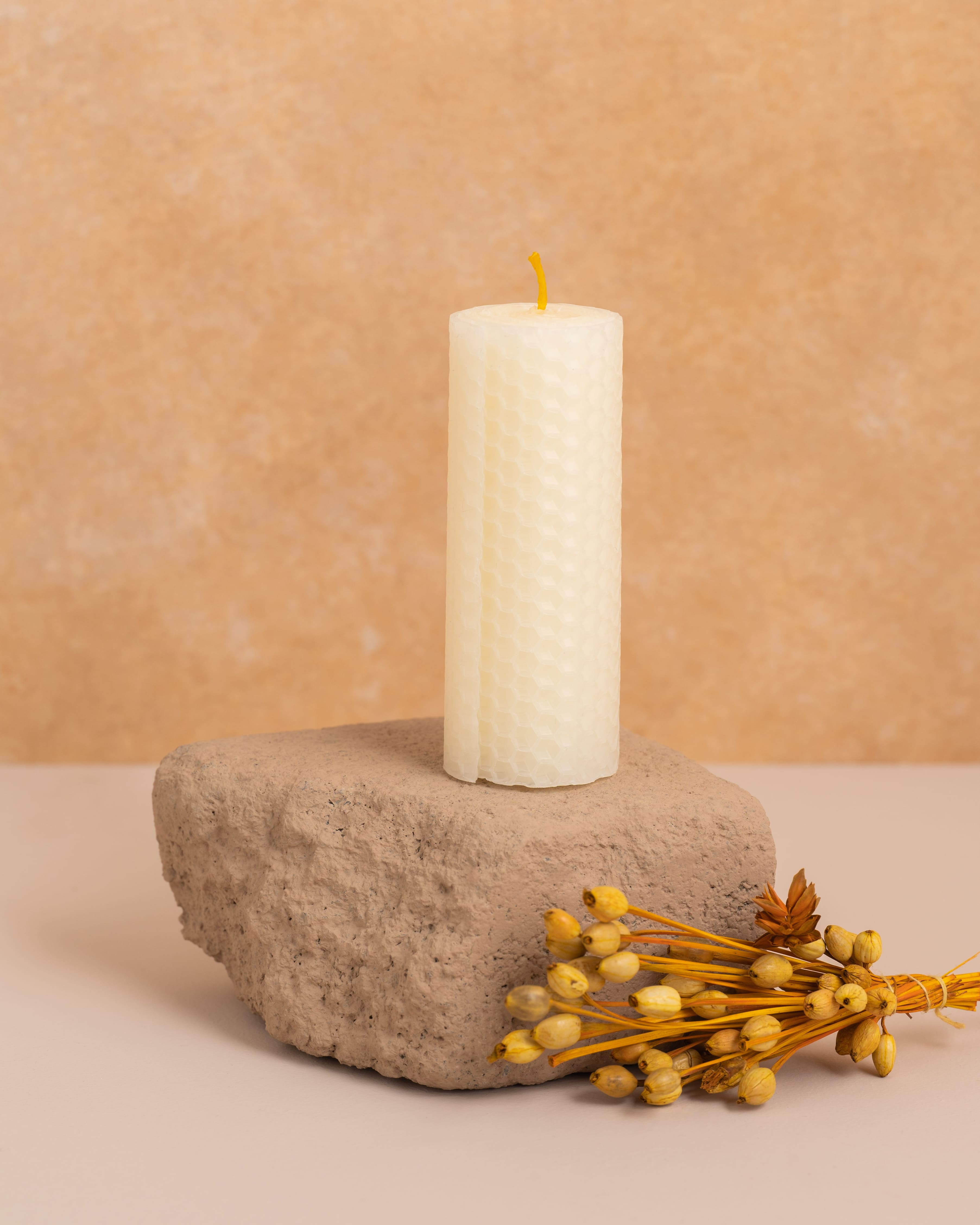 Vela em cera de abelha cor pérola branco com 10 cm de altura, produzida a partir de folhas de cera enroladas. Estrutura hexagonal inspirada nos favos de mel, perfeita para um ambiente puro e sofisticado.