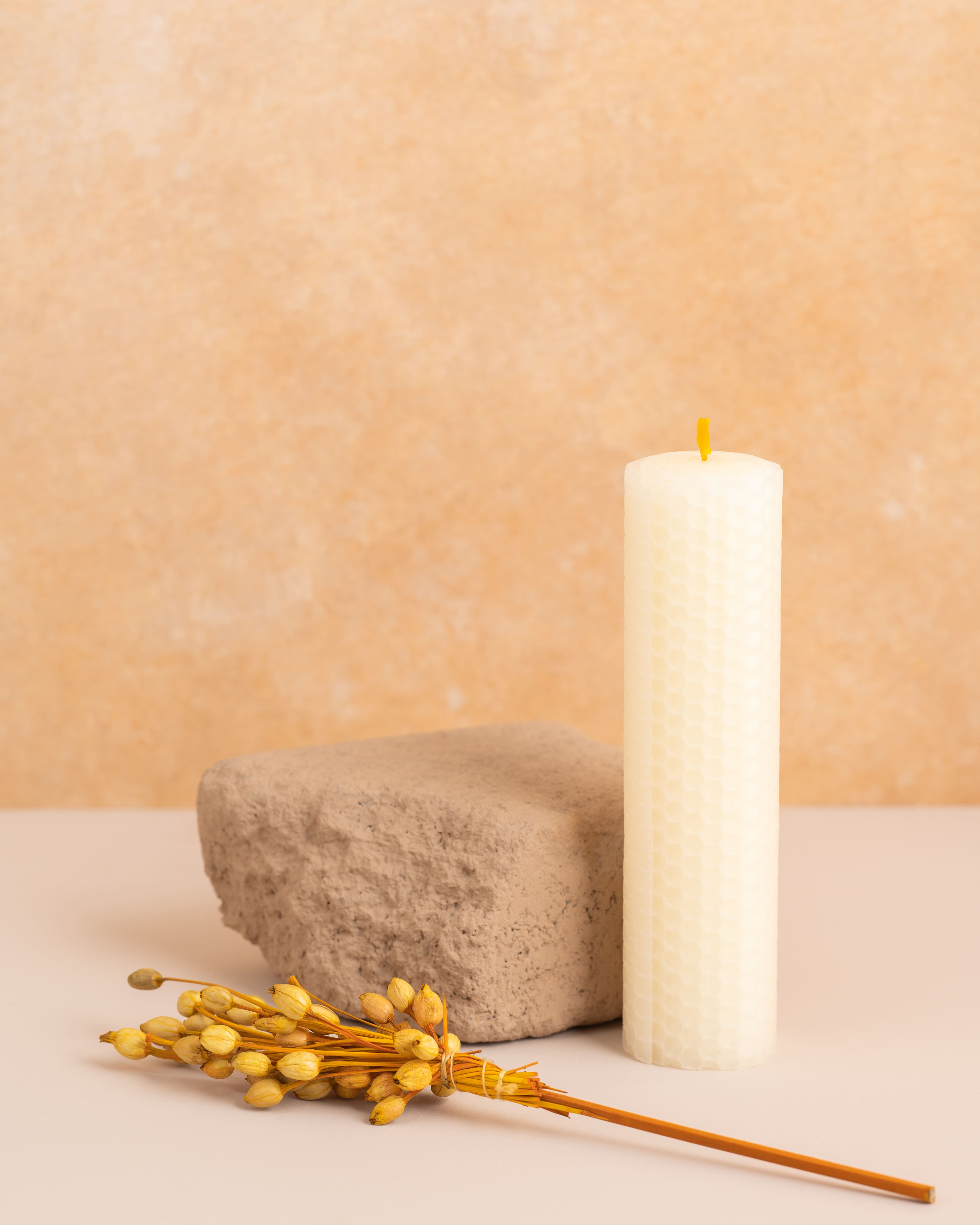 Vela artesanal em cera de abelha cor pérola branco com 15 cm de altura, criada através de folhas de cera enroladas. Textura natural dos favos de mel, ideal para uma decoração clean e sustentável.